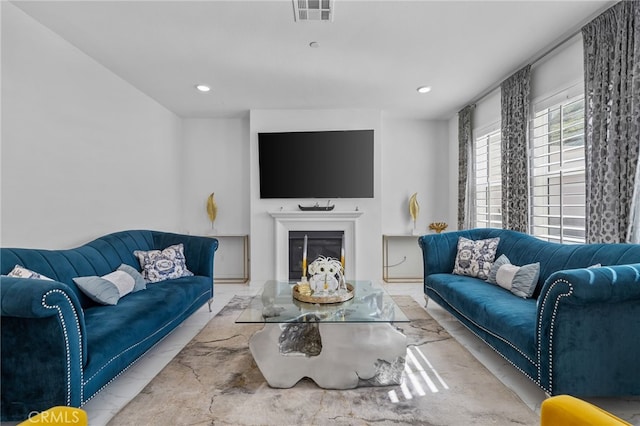 living area with recessed lighting, visible vents, and a glass covered fireplace