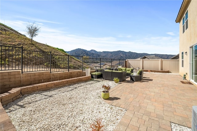 view of patio featuring outdoor lounge area, a fenced backyard, and a mountain view