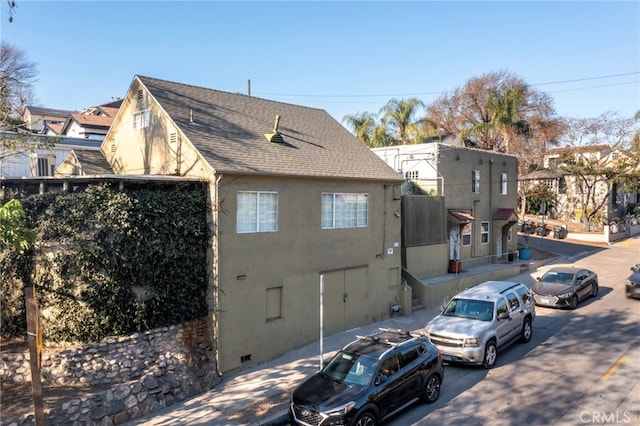 view of home's exterior featuring roof with shingles and stucco siding