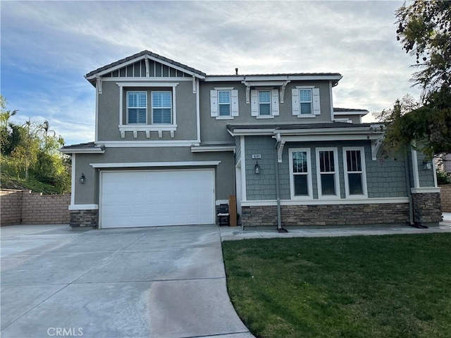 craftsman-style house featuring a garage, stone siding, a front lawn, and concrete driveway