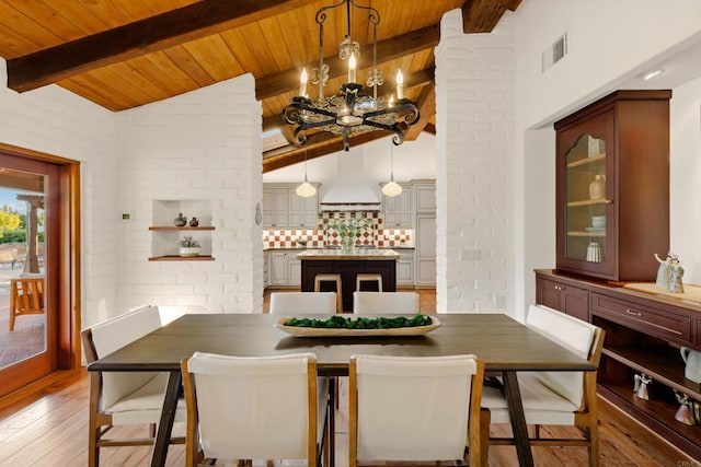 dining area with light wood-style floors, wooden ceiling, a notable chandelier, and vaulted ceiling with beams