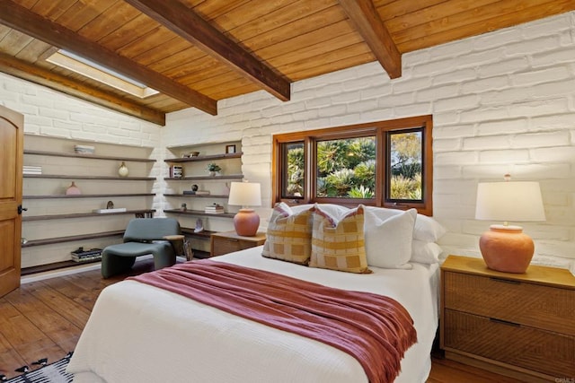 bedroom with lofted ceiling with skylight, wooden ceiling, and wood finished floors