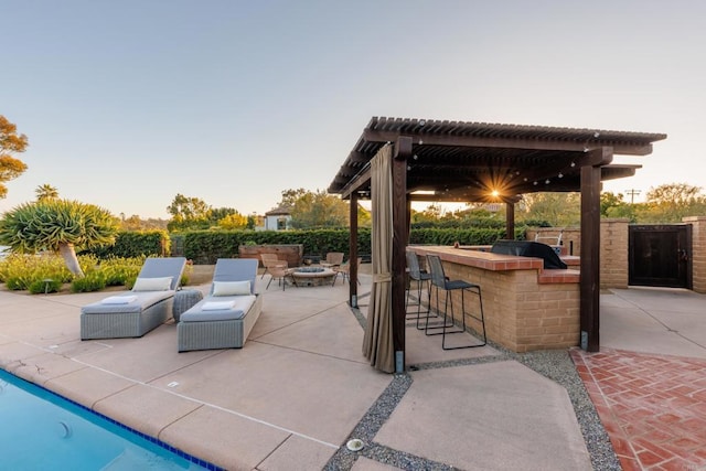 view of patio / terrace with outdoor dry bar, an outdoor fire pit, and area for grilling