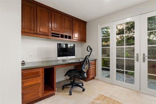 office space with light tile patterned floors, french doors, and built in desk