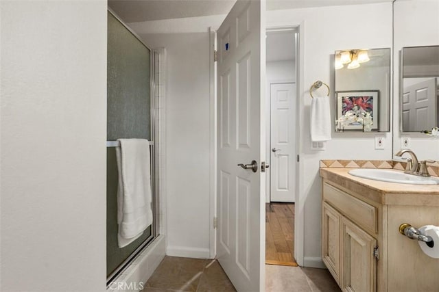 bathroom featuring tile patterned floors, a stall shower, and vanity