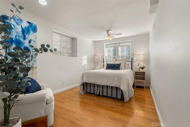 bedroom with light wood-style flooring, baseboards, and ceiling fan