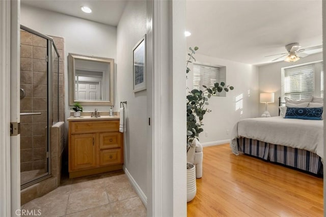 bedroom featuring light wood-type flooring, recessed lighting, baseboards, and a sink