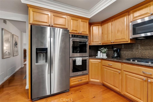 kitchen featuring visible vents, backsplash, ornamental molding, appliances with stainless steel finishes, and light wood-style floors