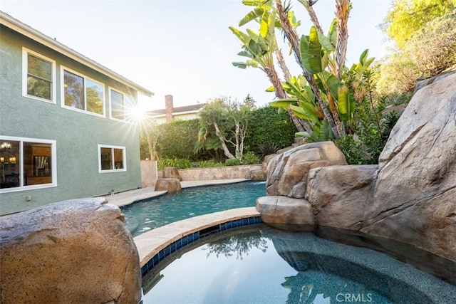 outdoor pool featuring an in ground hot tub