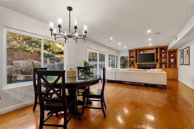 dining space with a notable chandelier, recessed lighting, baseboards, and wood-type flooring