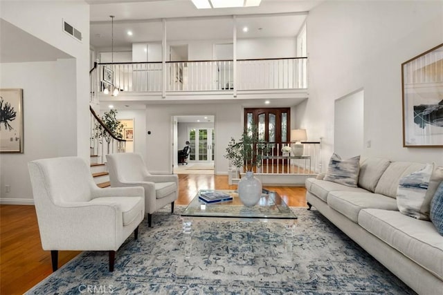 living room featuring stairway, a skylight, visible vents, and wood finished floors