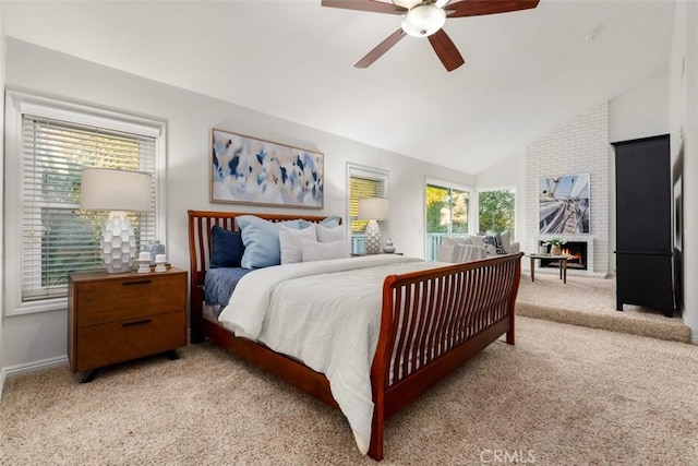 bedroom featuring baseboards, vaulted ceiling, light carpet, a fireplace, and a ceiling fan