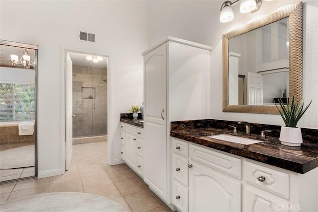 bathroom featuring tile patterned floors, visible vents, a stall shower, baseboards, and vanity