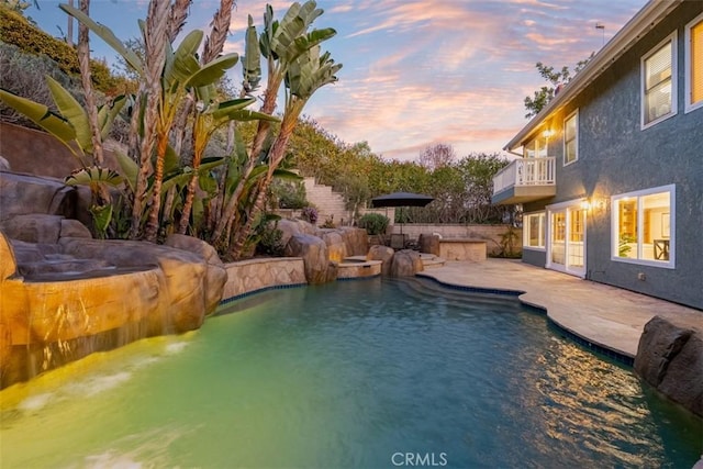 pool at dusk featuring a patio area and a fenced in pool