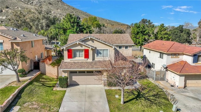 view of front of house with driveway, a tiled roof, an attached garage, and stucco siding