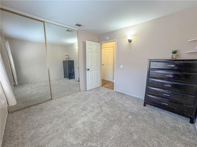 carpeted bedroom featuring a closet and visible vents