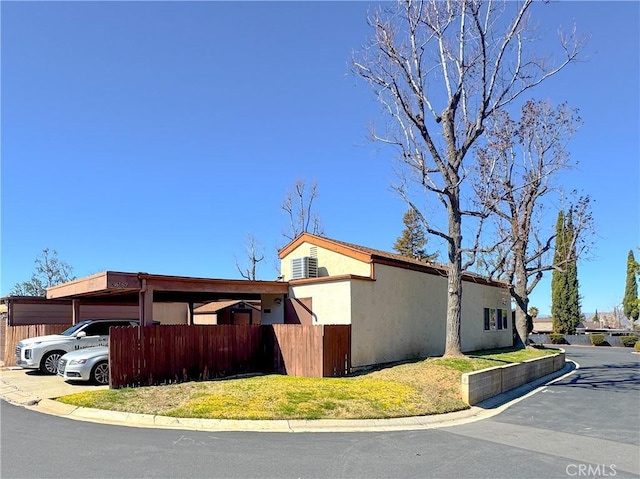 view of property exterior with fence and stucco siding