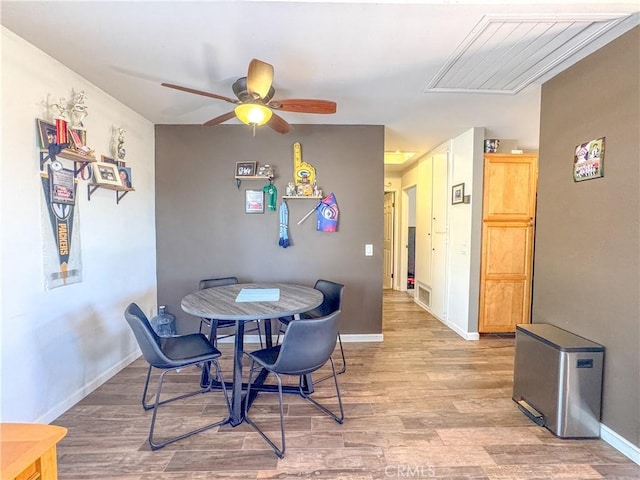 dining area featuring visible vents, wood finished floors, a ceiling fan, and baseboards