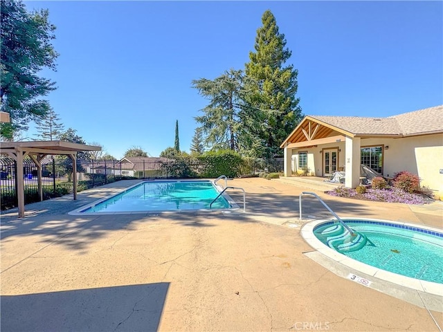 community pool with a patio area and fence