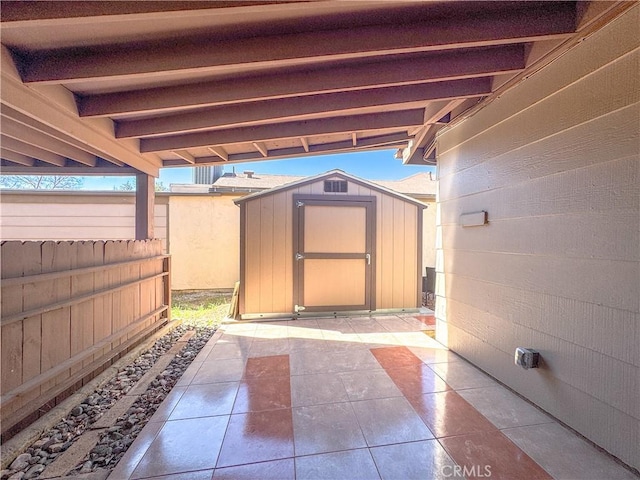 view of patio with a fenced backyard, a storage unit, and an outdoor structure