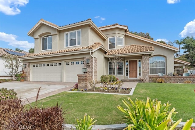 mediterranean / spanish house featuring a garage, concrete driveway, a front yard, and stucco siding