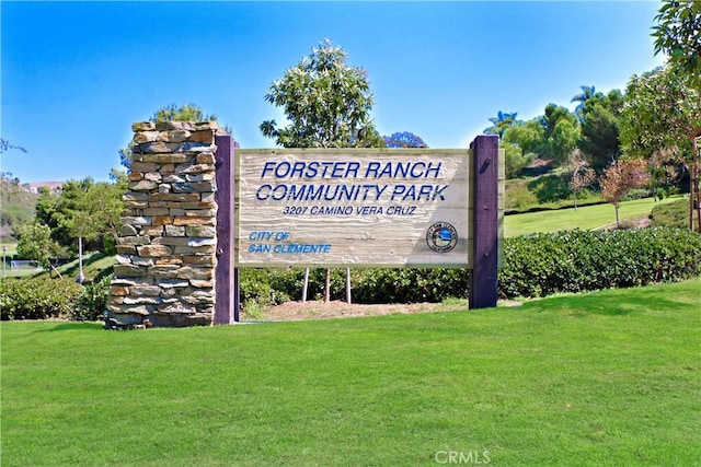 community / neighborhood sign featuring a lawn