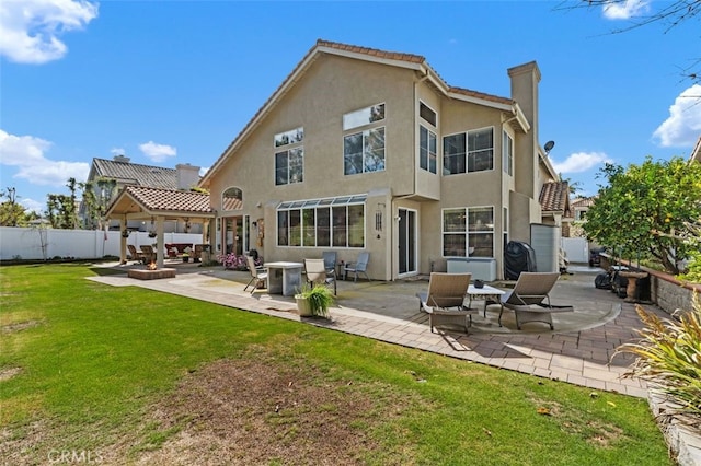 back of house with a patio, fence, a yard, stucco siding, and a chimney