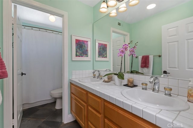 bathroom featuring visible vents, a sink, toilet, and double vanity