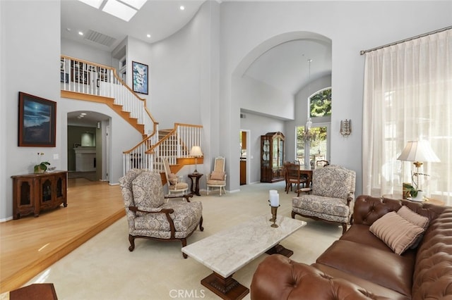 living room featuring arched walkways, stairway, wood finished floors, a high ceiling, and recessed lighting