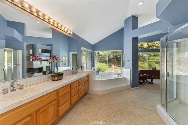 bathroom featuring double vanity, a garden tub, a sink, and a stall shower