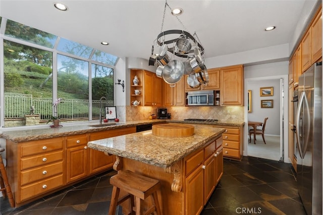 kitchen with a kitchen island, appliances with stainless steel finishes, a sink, open shelves, and backsplash