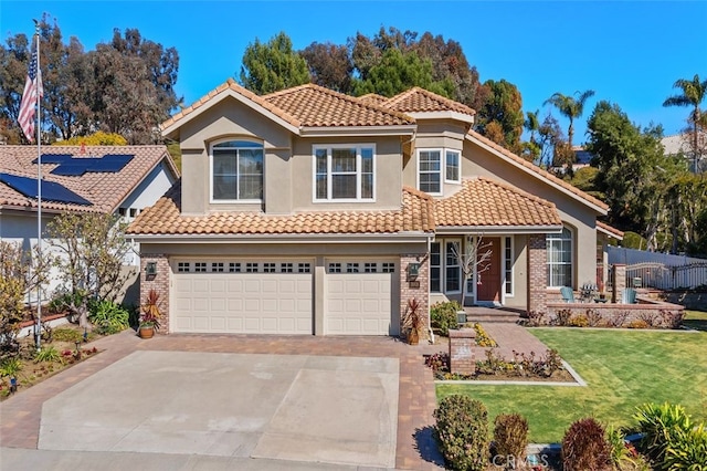 mediterranean / spanish house with concrete driveway, a front yard, a tile roof, and stucco siding