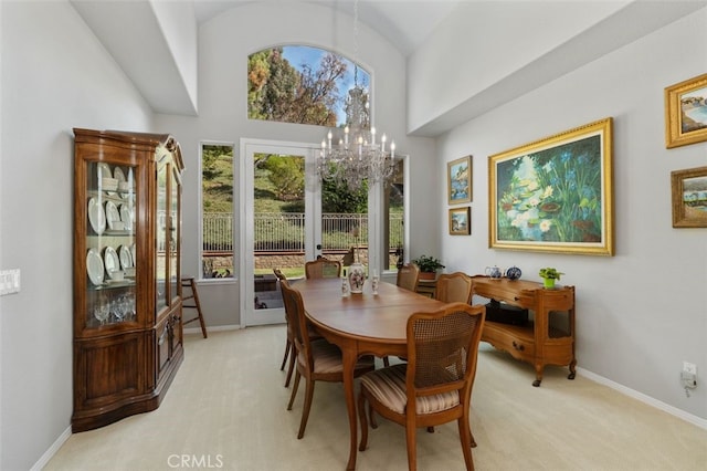 dining space featuring light carpet, baseboards, and an inviting chandelier