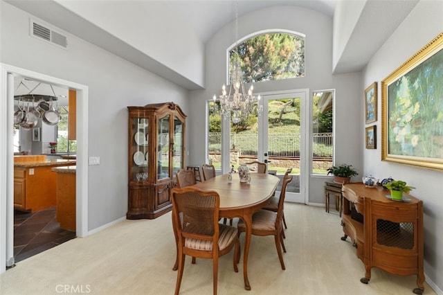 dining space featuring baseboards, visible vents, light colored carpet, french doors, and a notable chandelier