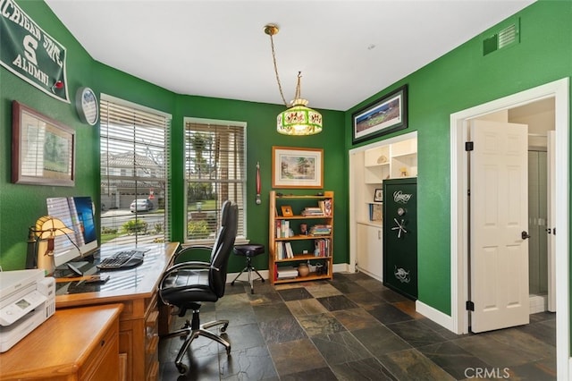 office area with baseboards, visible vents, and stone tile floors