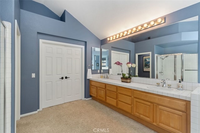 full bath featuring lofted ceiling, a stall shower, double vanity, and a sink