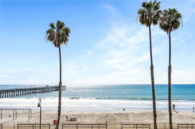 view of water feature with fence and a view of the beach