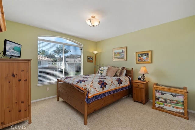 bedroom with light colored carpet and baseboards