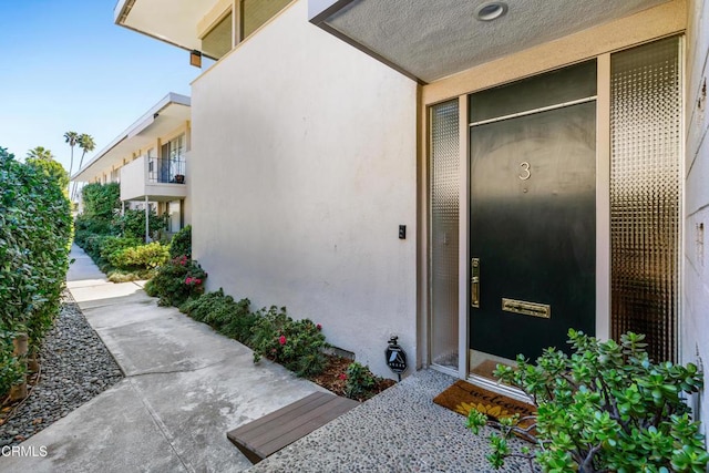 property entrance with stucco siding