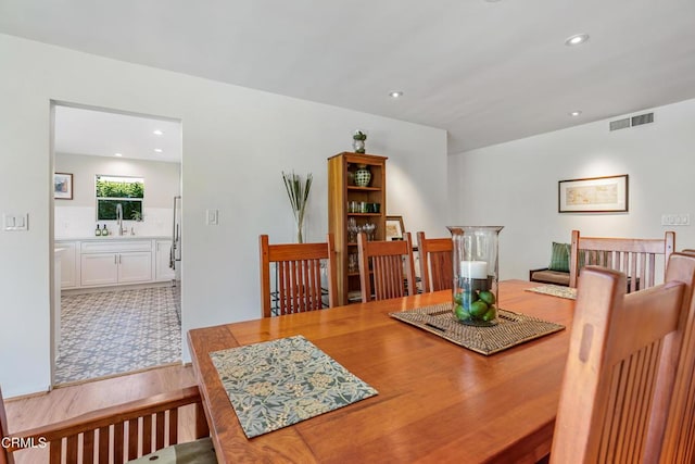 dining space with light wood-type flooring, visible vents, and recessed lighting