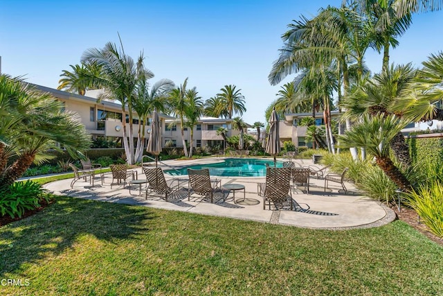 pool with a patio and a yard