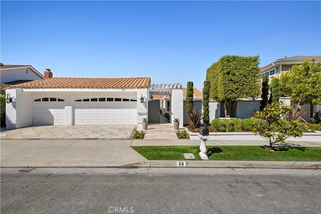 view of front of property featuring an attached garage, a tile roof, and stucco siding