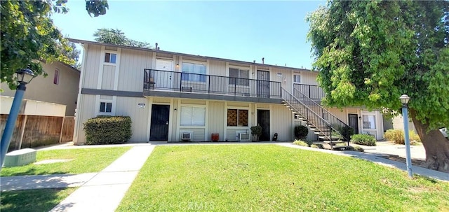 view of front of home featuring stairway and a front lawn