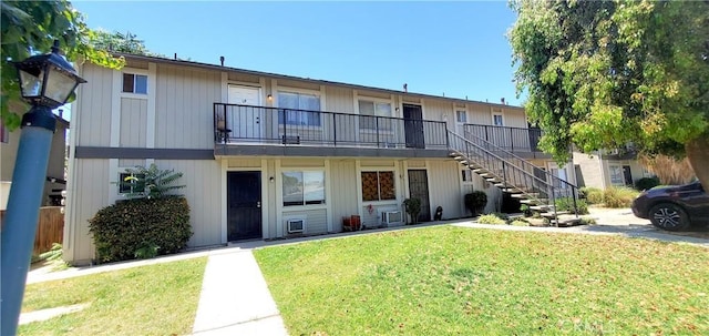 exterior space with stairway and a front yard