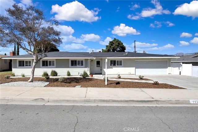 ranch-style house with driveway, an attached garage, and fence