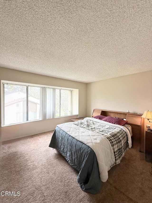 bedroom featuring a textured ceiling and carpet floors