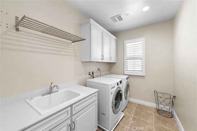 clothes washing area featuring cabinet space, visible vents, a sink, washer and dryer, and baseboards