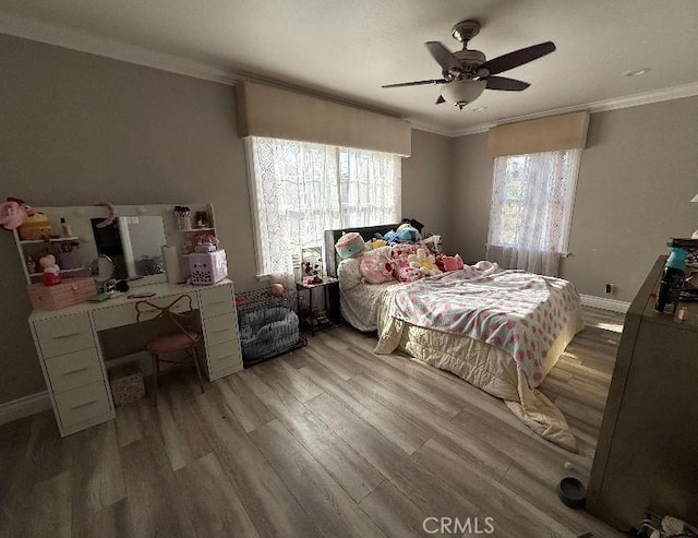 bedroom featuring ornamental molding, wood finished floors, a ceiling fan, and baseboards