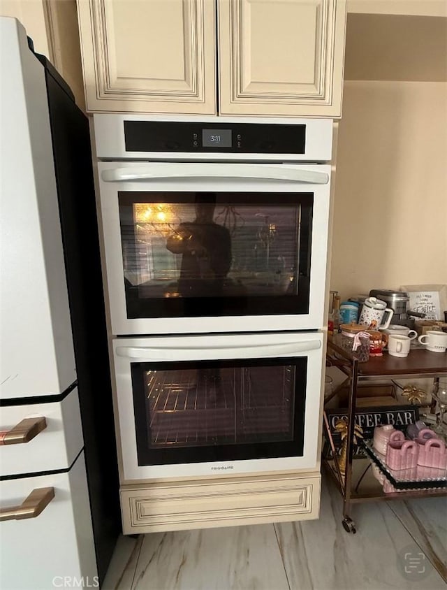 room details featuring double oven and cream cabinetry