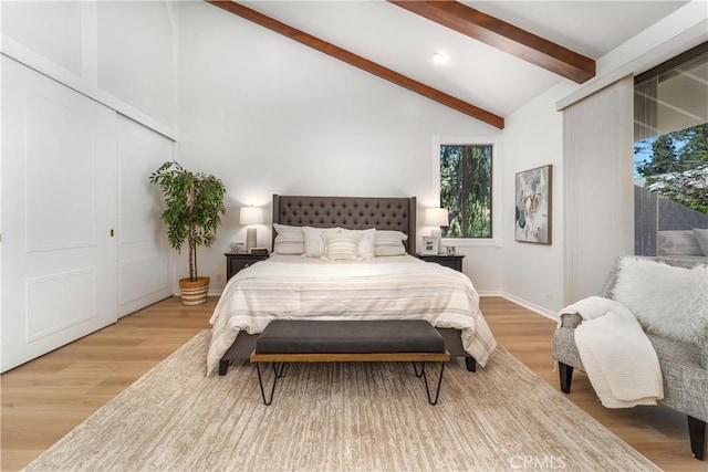 bedroom with vaulted ceiling with beams, baseboards, and wood finished floors